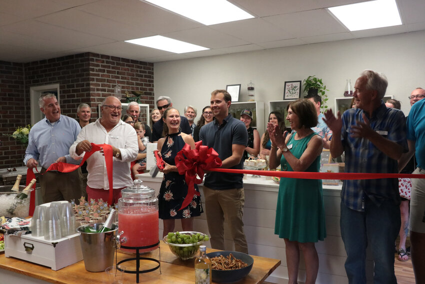 Members of the Littleton Chamber of Commerce, city officials, family and friends cheer at the ribbon cutting for Bridget's Botanicals on July 27.
